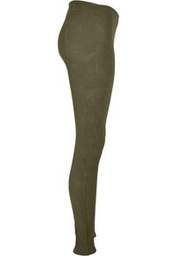 Vihreät legginssit, jotka on valmistettu sileästä ja joustavasta kankaasta. Niissä on korkea vyötärö ja ohut, istuva malli. Ei näkyviä saumoja tai kuvioita.