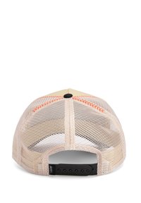 Cappellino trucker in mesh beige con una parte frontale solidale color tan, cuciture arancioni, cinturino regolabile snapback nero e un bottone nero arrotondato sulla parte superiore.