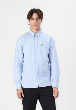 Light blue button-up shirt with a chest pocket, featuring a small yellow butterfly logo, made of soft fabric with a plain texture.