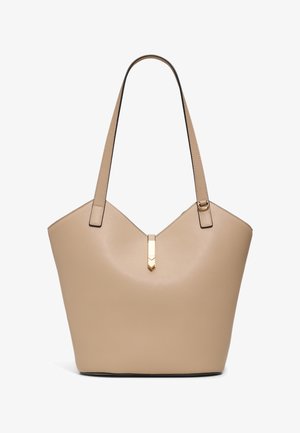 Sac fourre-tout en cuir beige avec deux bretelles et un fermoir décoratif doré au centre supérieur.