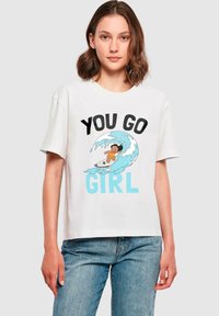 Hvit bomulls t-skjorte med et grafisk design med teksten "YOU GO GIRL" i fet svart og blå, samt en illustrasjon av en jente som surfer på en bølge.