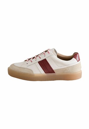 Sneakers with a white leather upper, red leather accents, beige suede details, and a gum rubber sole. Features red and white striped laces.