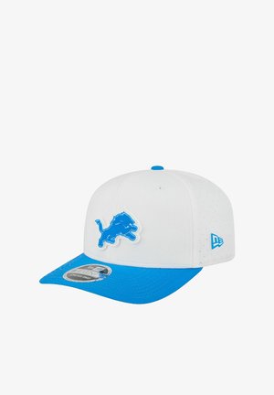 Weiße und blaue Baseballmütze mit blauem Löwenlogo auf der Vorderseite und New Era-Logo an der Seite, mit einem schwarz-weißen Aufkleber auf dem blauen Schirm.
