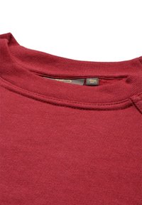 Felpa bordeaux con colletto a coste e tessuto testurizzato. L'etichetta all'interno del collo indica la taglia M. Superficie liscia con dettagli di cucitura minimi.
