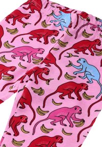 Legginsy w różowym materiale z powtarzającym się wzorem czerwonych i niebieskich małpek oraz żółtych bananów. Elastyczny pas, gładka faktura.