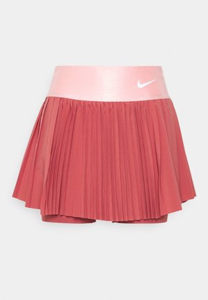Nike geplooide skort in koraal met een gladde roze tailleband. Voorzien van geïntegreerde short en een wit logo op de tailleband.