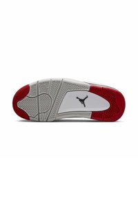 Suela de zapatilla blanca con un acento en el talón rojo, que presenta un patrón de goma texturizado y un logotipo negro en el centro. Diseño liso y robusto.