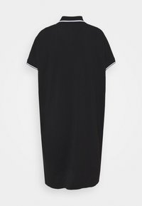 Černé polo šaty s krátkým rukávem a bílým lemováním na límci a manžetách, zobrazené zezadu na jednobarevném bílém pozadí.