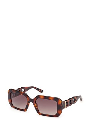 Ochelari de soare cu model tartă de broască țestoasă, cu o formă geometrică, lentile cu gradient și un design cu lănțișoare pe brațe. Accentuati cu accesorii aurii.