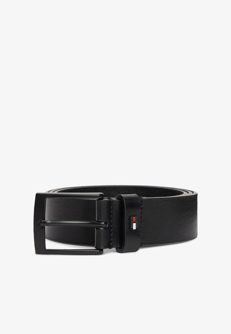 Ceinture en cuir noire enroulée avec une boucle rectangulaire en métal noir et petit logo rouge, blanc et bleu sur la boucle de ceinture.