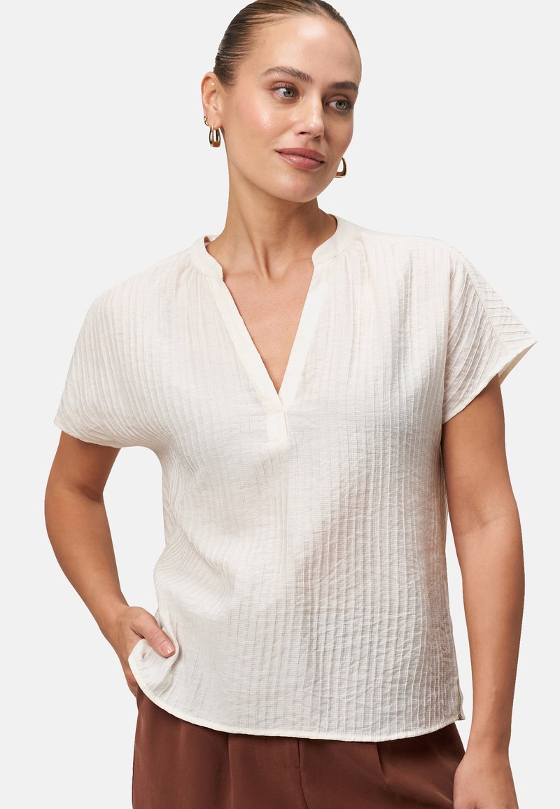 Blusa bianca a maniche corte con scollo a V, in tessuto strutturato caratterizzato da sottili righe verticali e una vestibilità comoda.
