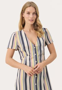 Robe rayée en tissu léger avec un décolleté en V, des manches courtes bouffantes et des boutons sur le devant ; les couleurs incluent le marine, le rose et le jaune.