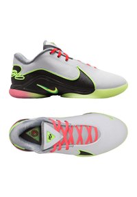 Zapatillas Nike con parte superior de malla gris, detalles en negro, detalles en verde neón y cordones rosas. Presenta una suela texturizada y un logo triangular.