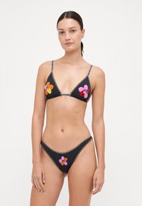 Schwarzes Bikini-Set mit dreieckigem Oberteil und tief sitzenden Hosen; ausgestattet mit mehrfarbiger Blumenstickerei und Kontrastnähten.