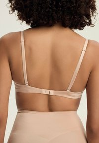 Nagi, bezszwowy biustonosz z regulowanymi ramiączkami i zapięciem na haftkę. Miękka tkanina o gładkiej fakturze i minimalistycznym wzornictwie.