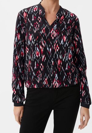 Langarmbluse in Schwarz mit rotem und blauem abstraktem Muster, mit V-Ausschnitt und elastischen Bündchen, aus leichtem Stoff gefertigt.