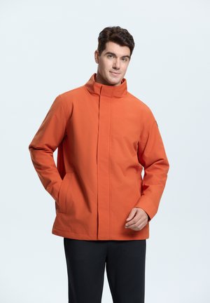 Oranžová nepromokavá bunda s vysokým límcem, bočními kapsami a zipovým uzávěrem. Tkanina vypadá hladce s matným povrchem.