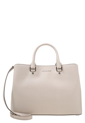 Michael Kors håndtaske i cremefarvet læder med to håndtag og en aftagelig skulderrem på en hvid baggrund.