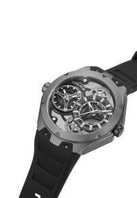 Orologio con cinturino in gomma nera e cassa in acciaio inossidabile argentato, dotato di doppio fuso orario, design scheletrato intricato e marcatori delle ore audaci.