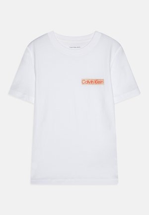 Baltas kokvilnas T-krekls ar apaļu kakla izgriezumu, īsām piedurknēm un oranžu izšūtu Calvin Klein logo kreisajā krūšu kabatā.