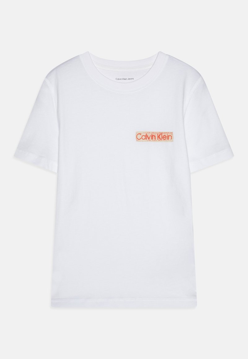 Baltas kokvilnas T-krekls ar apaļu kakla izgriezumu, īsām piedurknēm un oranžu izšūtu Calvin Klein logo kreisajā krūšu kabatā.