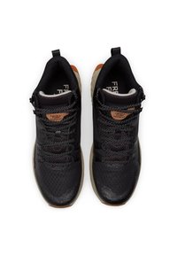 Un paio di scarpe da allenamento nere e beige con lacci pattern, tomaia in mesh e etichetta "Fresh Foam Hierro HT" sulla linguetta, vista dall'alto.