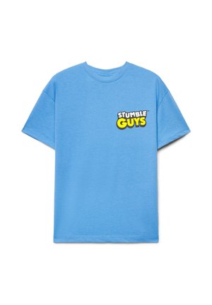 T-shirt azzurro chiaro a maniche corte con il logo "STUMBLE GUYS" bianco e giallo sul lato sinistro del petto, sfondo semplice.