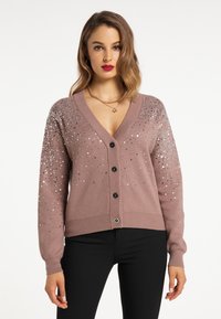 Cardigan roz deschis din tricot moale, cu decolteu în V adânc, cinci butoane negre și paiete argintii dispersate pe umeri.