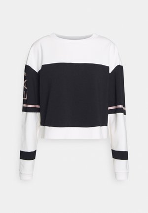 Long-sleeve cropped sweatshirt with black and white color blocks and pink stripes on sleeves and chest.