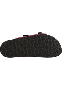 Zwarte rubberen sandaalzool met een gestructureerd, honingraatpatroon; heeft roze accenten langs de rand en twee verstelbare zwarte klittenbandsluitingen.