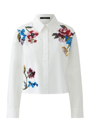 Chemise blanche à manches longues avec cols pointu, boutonnée à l'avant, ornée de broderies de sequins floraux multicolores sur les épaules et le côté gauche avant.