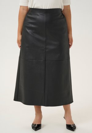 Black leather midi skirt with a smooth texture, featuring vertical seams and a straight cut. Paired with pointed black shoes.