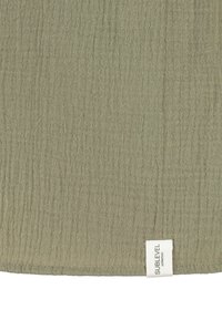 Texturiertes, olivgrünes Gewebe mit einem dezenten gestreiften Design; versehen mit einem Etikett mit der Aufschrift "SUBLEVEL" in der unteren linken Ecke.