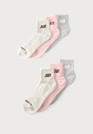 Deux lots de trois chaussettes chevilles en blanc, rose et gris, chacune avec un logo près du bord-côte et un texte sur la zone des orteils.