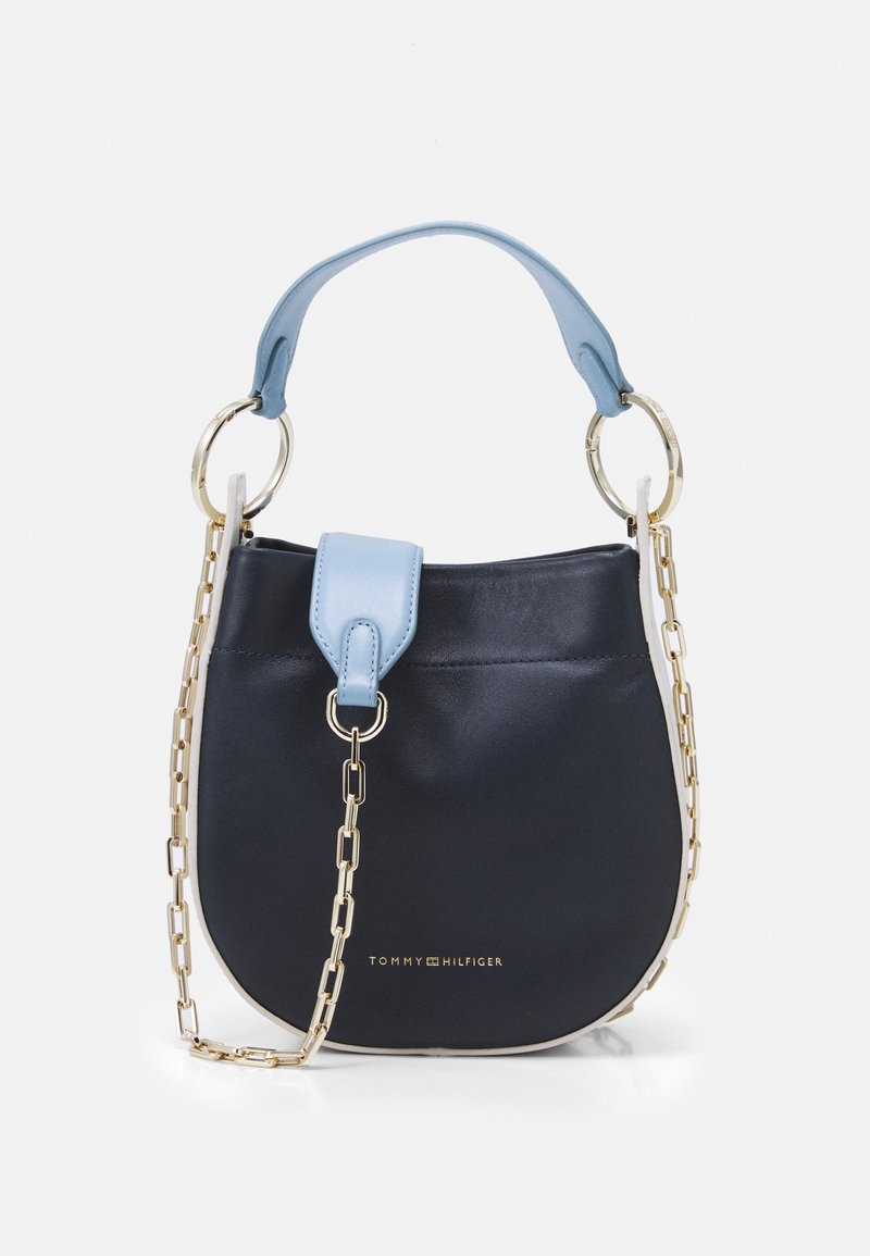 Petit sac à main noir avec poignée et rabat bleu clair, bandoulière chaîne dorée, et logo Tommy Hilfiger à l'avant.