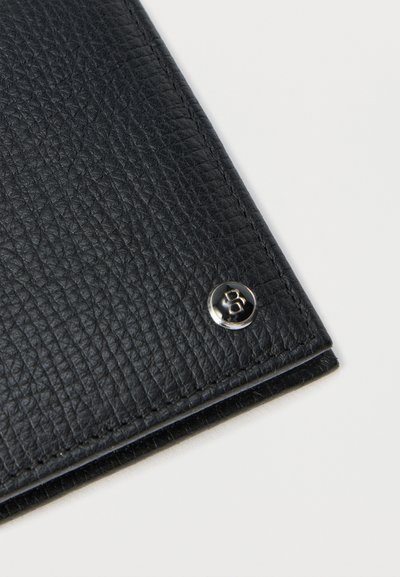 Coin de portefeuille en cuir noir texturé avec un bouton argenté comportant un logo "B" sur fond blanc.