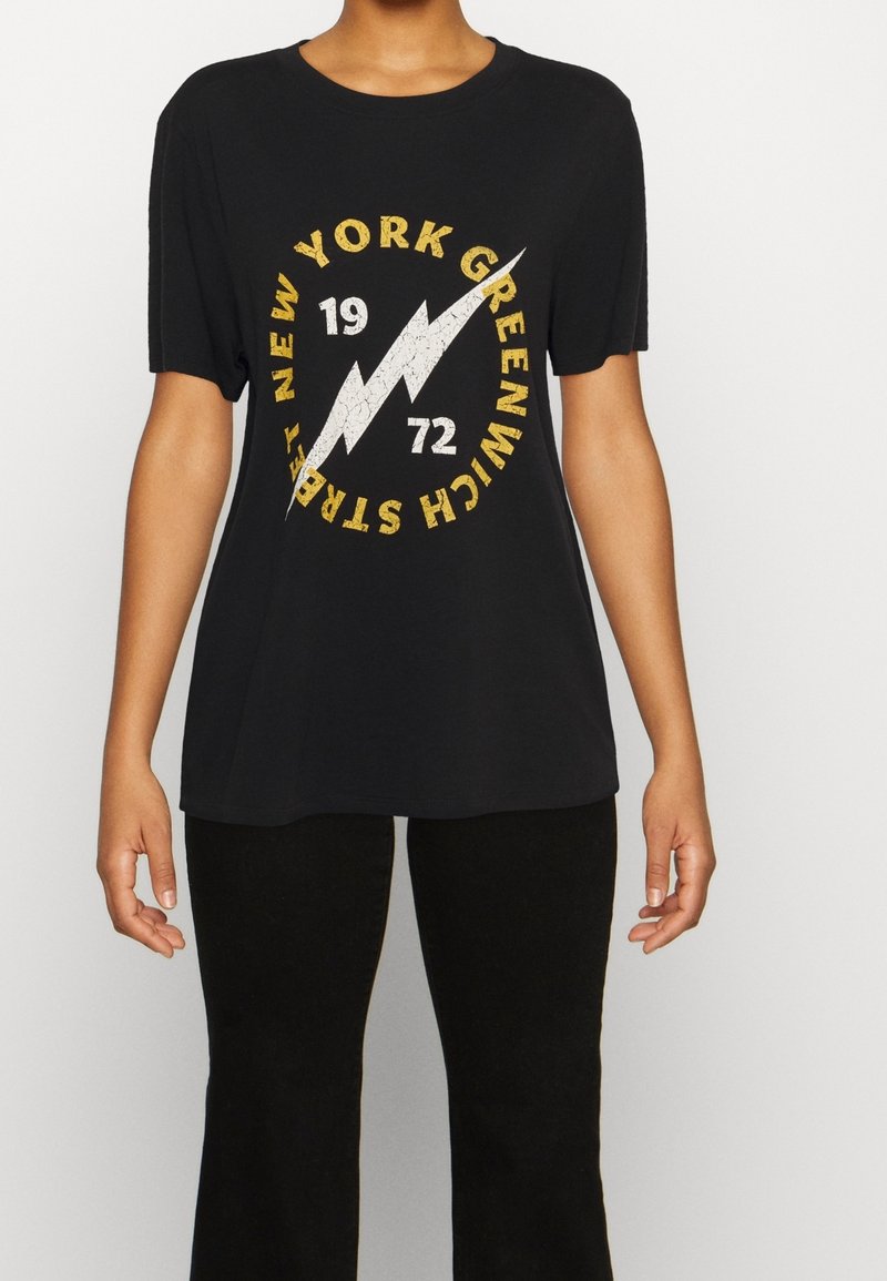Černé tričko s kulatým grafickým designem, který obsahuje text "NEW YORK GREENWICH", design blesku a opotřebené žluté a bílé akcenty.