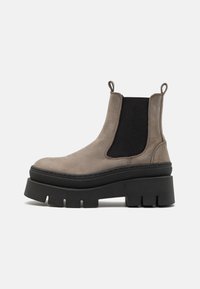Botas Chelsea de cuero gris con suela de goma negra alta y gruesa, paneles laterales elásticos y tiradores para un fácil calzado.