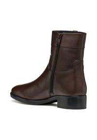 Botas de tobillo de cuero marrón con cierre lateral, punta redonda y tacón bajo tipo bloque. Textura suave con un detalle de costura minimalista.