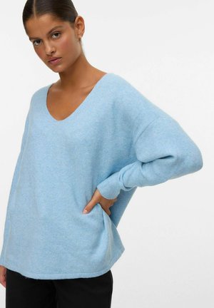 Pull bleu clair surdimensionné en tissu doux et texturé, avec un décolleté en V profond et des manches longues, doté de poches latérales et d'un ourlet arrondi.