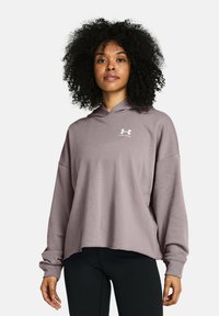 Sudadera lila con un ajuste relajado, mangas largas y capucha con cordón; presenta un logo blanco en el pecho y un dobladillo sin rematar.