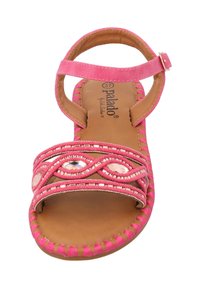Bright pink sandal with braided straps, embellished with clear gemstones, and a flat brown sole. Open toe and ankle strap design.