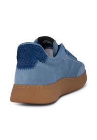 Blue suede sneaker featuring a textured navy heel accent, brown rubber sole, and subtle stitching details on the side and heel.