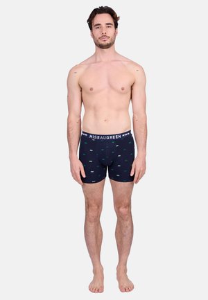 Boxer-culottes bleu marine avec une texture douce, présentant un motif répété de petits ours verts et blancs. La ceinture est marquée "Miseaugreen."