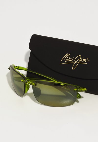 Ochelari de soare verzi cu un design tip wraparound și lentile gri, însoțiți de un capac negru cu un branding auriu "Maui Jim".