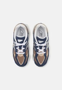 Scarpe da ginnastica navy e beige caratterizzate da materiali in rete e suede, punta rotonda, lacci bianchi e accenti in logo argentato sui lati.
