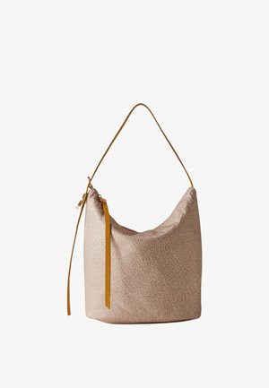 Sac hobo beige texturé avec bandoulière en cuir fauve et tirette de fermeture éclair sur fond blanc uni.