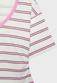 Tessuto bianco con righe orizzontali rosa e sottili nere, manica corta e bordo rosa intorno a una scollatura a giro.