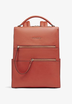 Mochila de cuero marrón en forma cuadrada con dos bolsillos frontales con cremallera y asa superior.