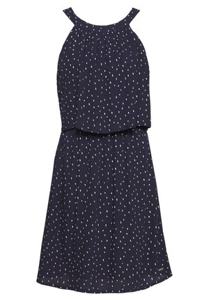 Robe bleu marine sans manches avec motif à pois blancs, encolure froncée et haut superposé sur une jupe évasée.